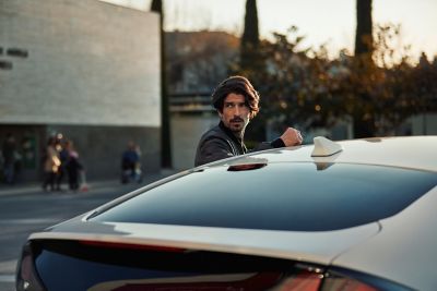 Homme debout à côté de Hyundai IONIQ.