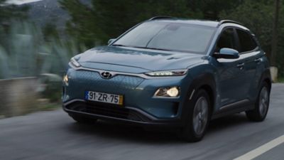 The back of the Hyundai IONIQ 5 with a woman standing in front of it.