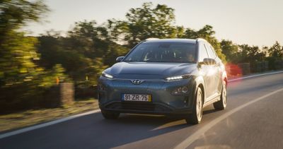 The Hyundai IONIQ 5 full electric vehicle driving down a country road.  