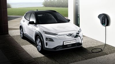 Véhicule électrique Hyundai KONA en cours de recharge dans un garage.