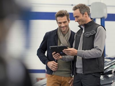 Hyundai fleet speaking to customer with tablet in hand. 