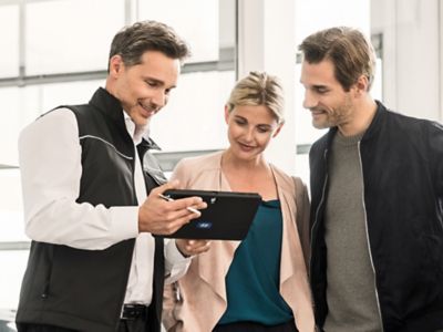 Hyundai Service Expert talking to customers with an iPad in his hands.