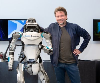 Marc Theermann, strategileder for Boston Dynamics, står sammen med roboten Atlas. Foto.