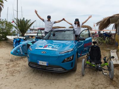 Alana Alvarez and Manuel Bustelo cheering in their Hyundai KONA Electric on the beach