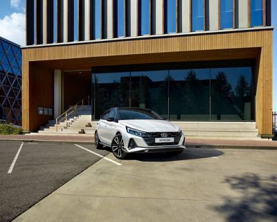 The Hyundai i20 N Line in front of a building with large windows