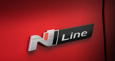 Het N Line-logo in reliëf op de Hyundai KONA N Line in het rood. 