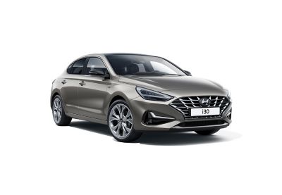 The all-new Hyundai i30 Fastback pictured from the rear parked on a city street.