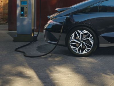Hyundai IONIQ 6 all-electric sedan plugged into a charging station.
