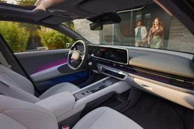 Interior del IONIQ 6 Eléctrico con dos personas situadas junto a él. 