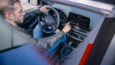 Driver in the Hyundai i30 N using the 10.25" touchscreen.  