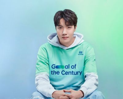 BTS member J-hope wearing a  Hyundai Team Century shirt with Goal of the Century on the front.