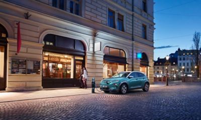 Un Hyundai KONA se recharge électriquement à une station de recharge autonome publique.