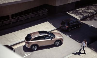 Pohled shora na zcela nový Hyundai Nexo, na sluncem zalité ulici.