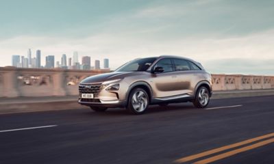Side view of the Hyundai Nexo driving on a street.