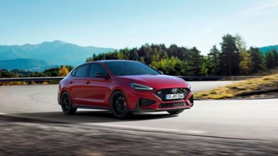 Nuevo Hyundai i30 N en color Sunset Red en una curva.