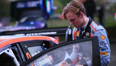 Hyundai Motorsport driver Oliver Solberg getting next to his rally car.