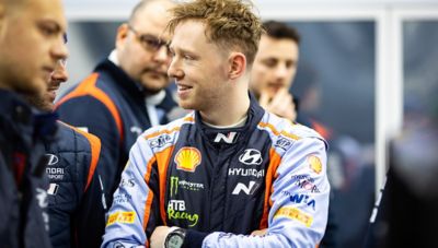 Hyundai Motorsport co-driver  Elliott Edmondson smiling before a race.
