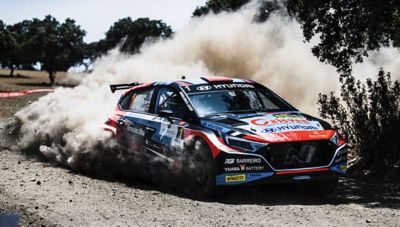 A Hyundai Rally2 car drifting through a corner.