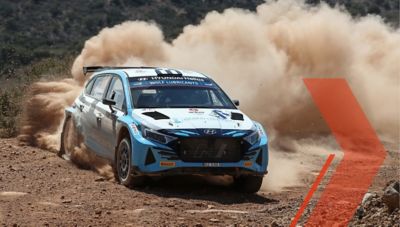 Hyundai i20 N Rally2 throwing up dust in a curve during a rally