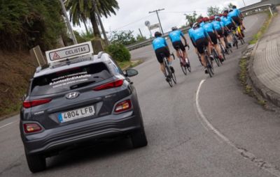 Vehículo Hyundai escoltando ciclistas.
