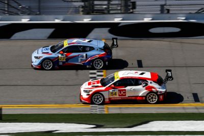 Two Hyundai Motorsport i30 N TCR in action on a racetrack shown from above.