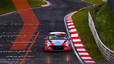  A picture of Hyundai Motorsport’s i30 N TCR in action on a racetrack shown from the front.