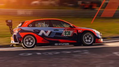 The Hyundai Motorsport customer racing i30 N braking on racetrack.