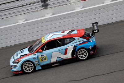 A picture of Hyundai Motorsport’s i30 N TCR in action on a racetrack shown from the side.