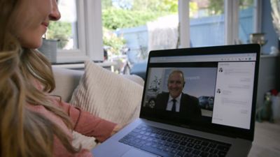 A customer speaking with a Hyundai sales rep via video chat on her laptop.