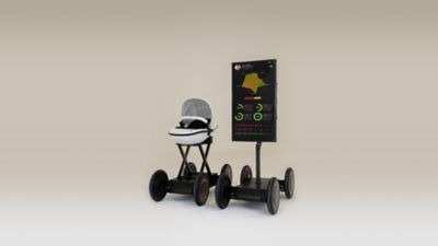 Droide de movilidad excéntrica MobED sosteniendo un carrito de bebé y una pantalla con estadísticas.