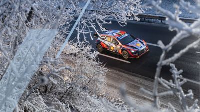 The Hyundai i20 Coupe WRC car creating some spray in the snow. 