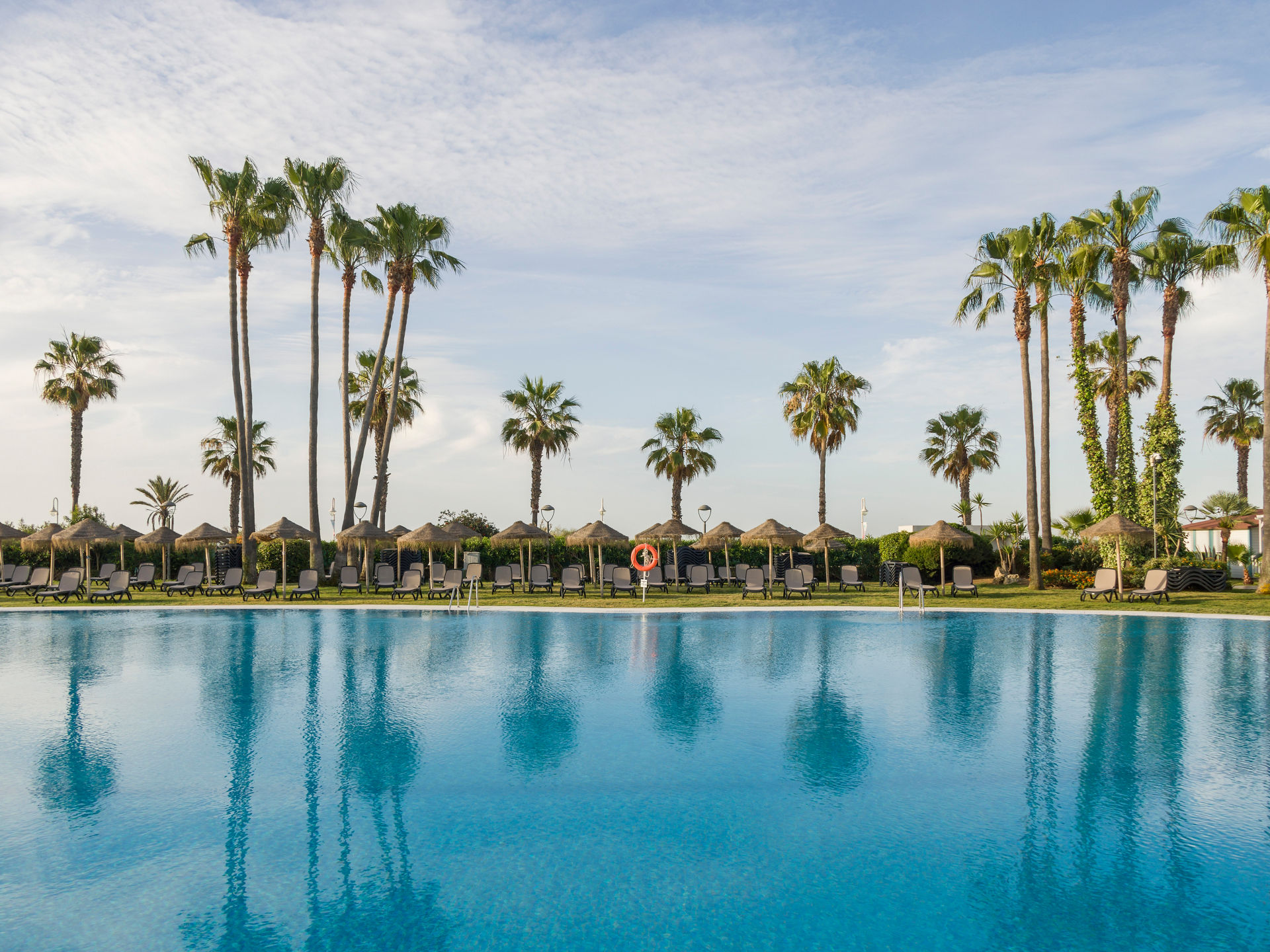 vista exterior del hotel con la piscina y el mar de fondo