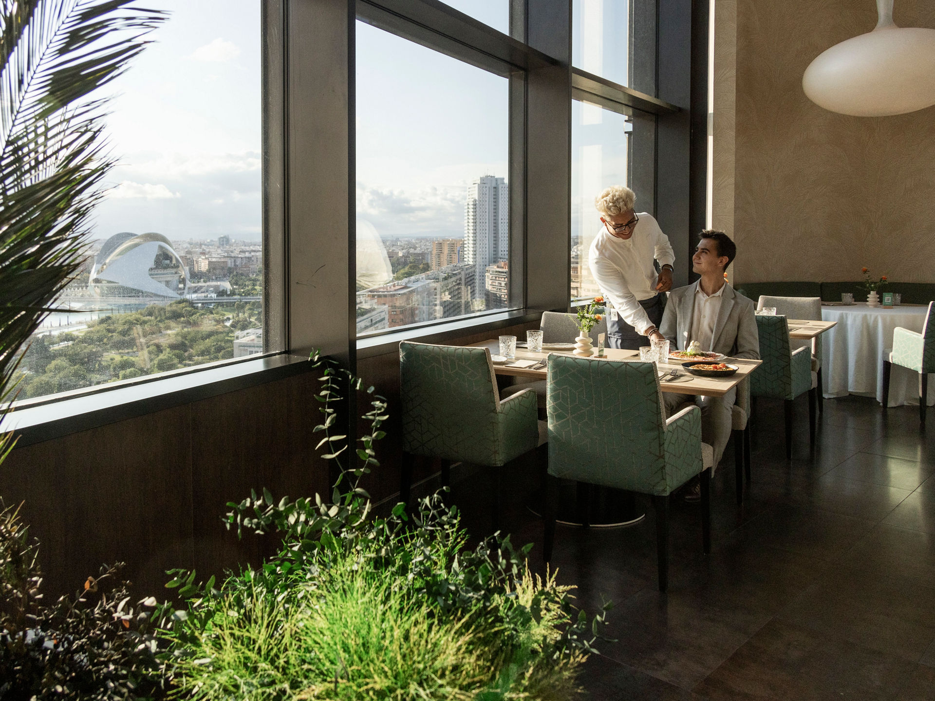 camarero sirve copa de vino en mesa de restaurante Umániko Aqua