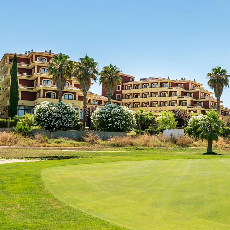 pista de golf con el hotel ILUNION Golf Badajoz en el fondo 
