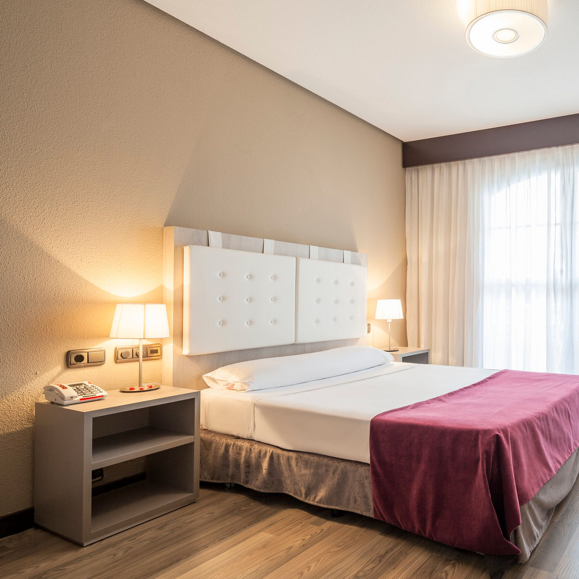amplia habitación accesible iluminada con la lámpara de la mesilla de noche