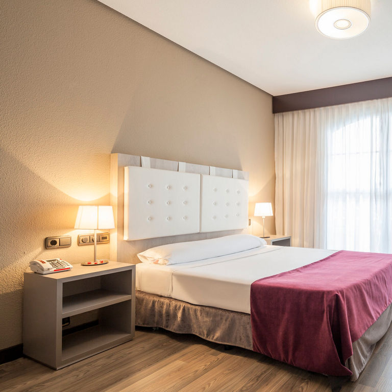 amplia habitación accesible iluminada con la lámpara de la mesilla de noche