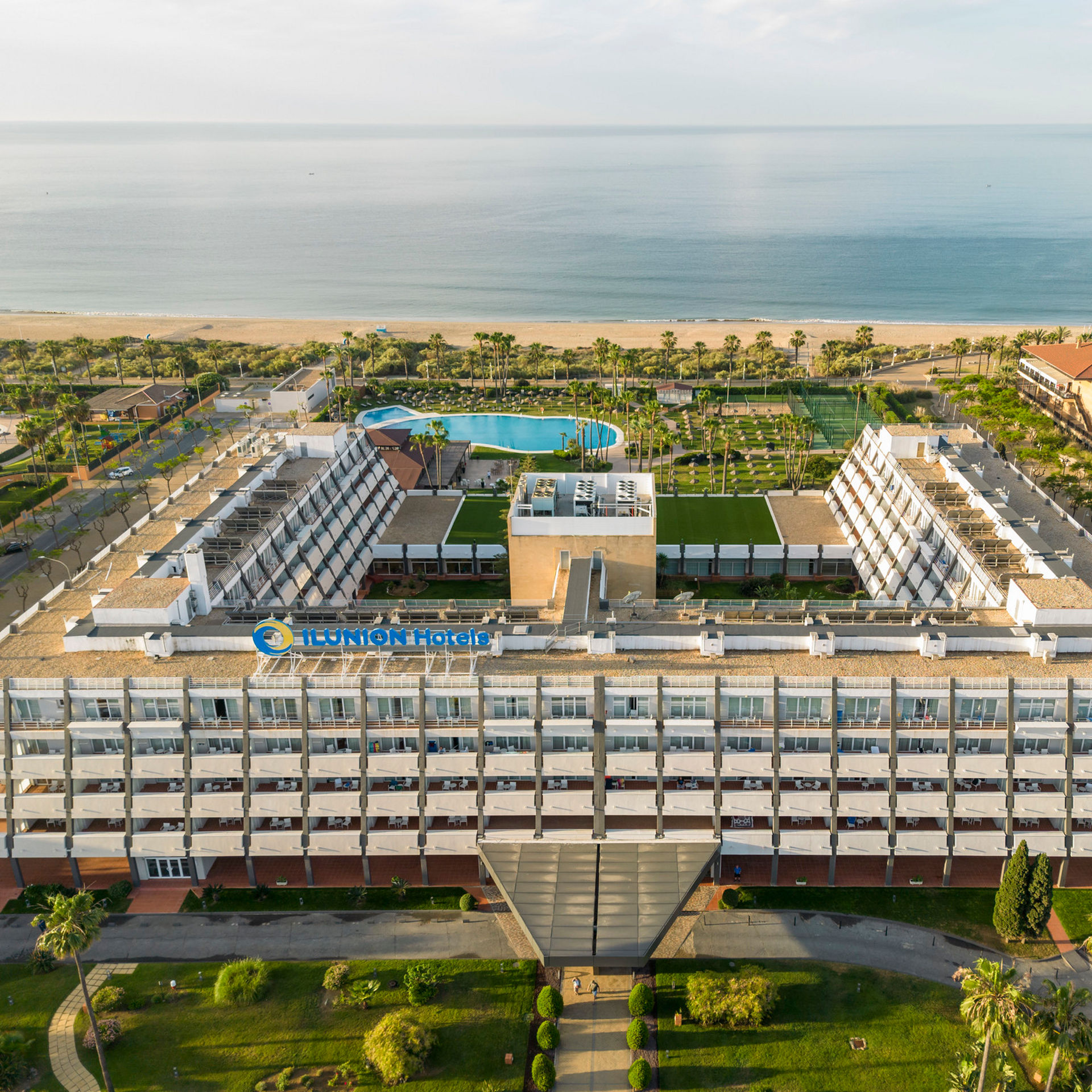 vista exterior del hotel con la piscina y el mar de fondo