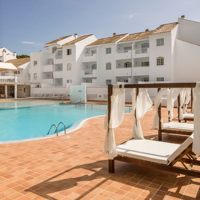 piscina del hotel con cómodas camas al lado