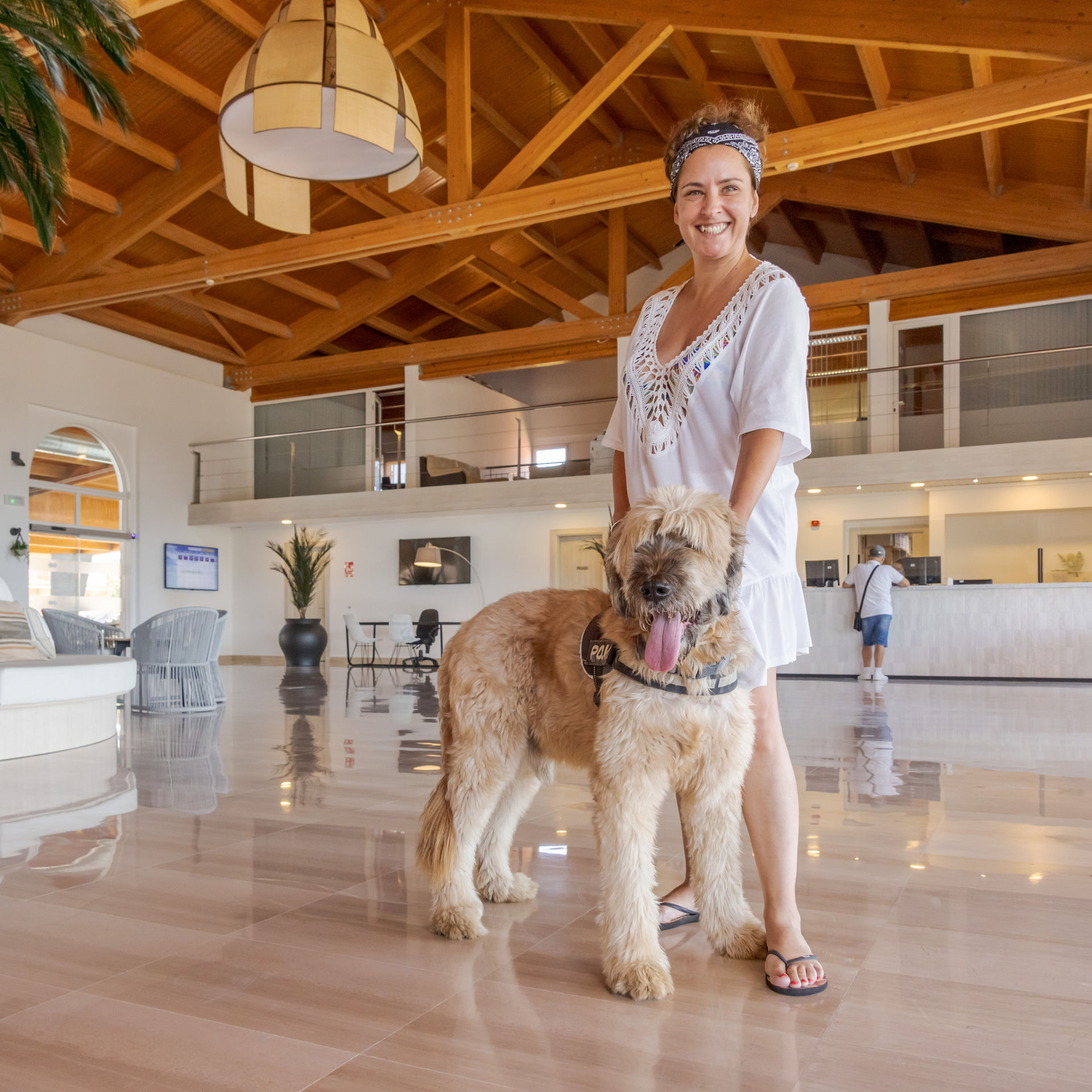 mujer con su perro en la recepción del hotel