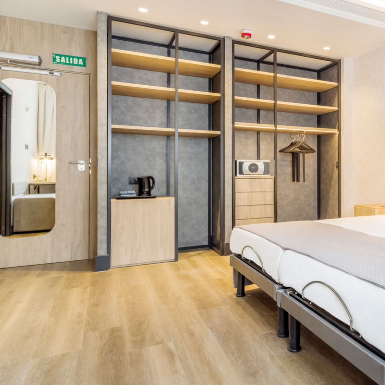 Amplia habitación con cama doble, espejo y armario accesible
