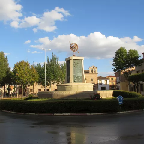 Plaza circular con monumento y zonas ajardinadas