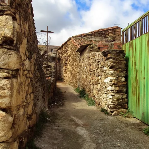 Calle estrecha con muros de piedra y pavimento rústico