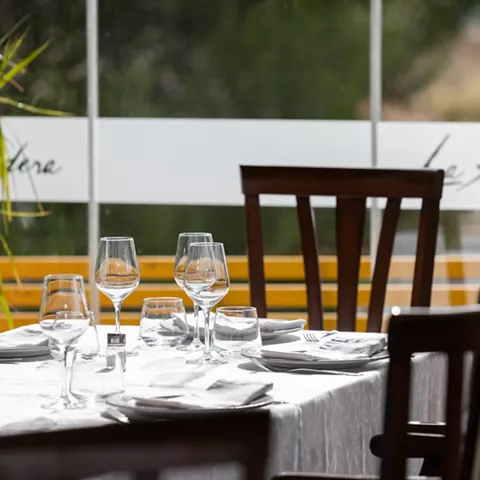 Mesa elegante junto a ventanal con copas preparadas