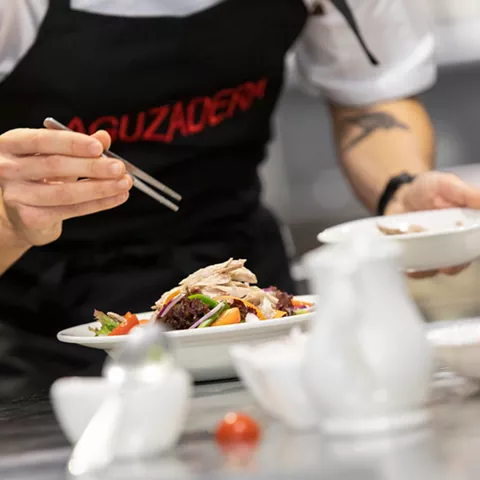 Chef finalizando plato en cocina profesional