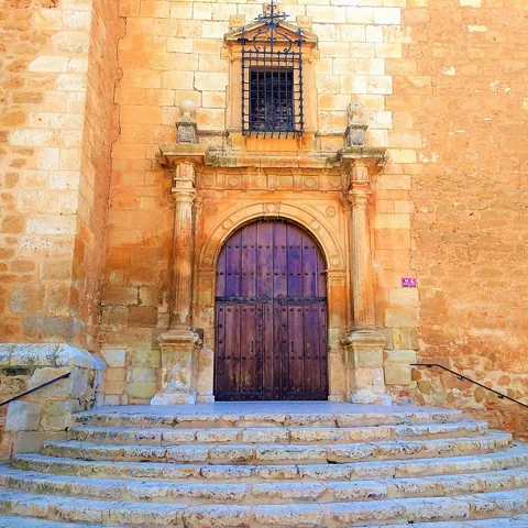 Portada de piedra con arco y escalinata de acceso