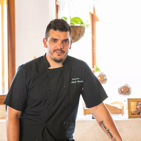 Chef con chaqueta negra en comedor luminoso