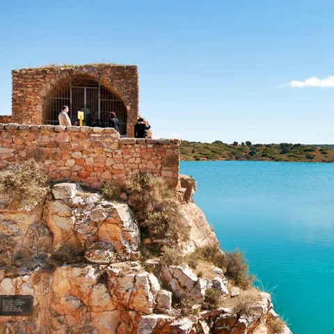 Ermita sobre acantilado junto a laguna