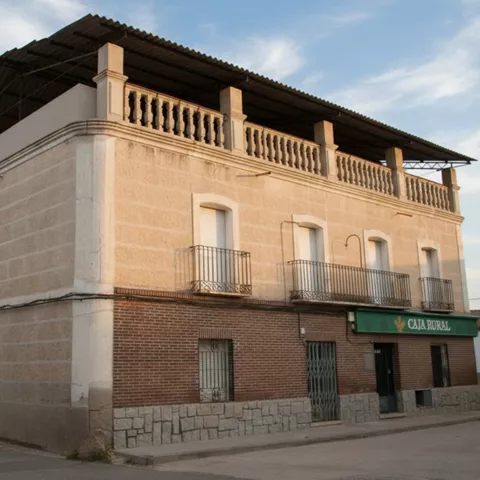 Edificio histórico de dos plantas con balcones y fachada de ladrillo.