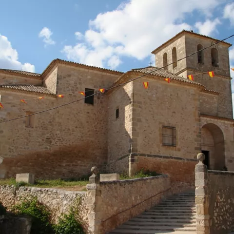 Iglesia de piedra con escalinata y torre campanario