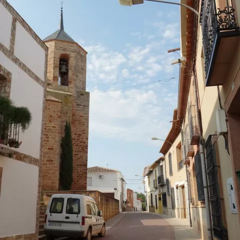 Calle estrecha con torre de piedra al fondo